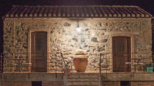 San Demetrio CoroneLa Giara B&B的石头房子前面有一个大花瓶