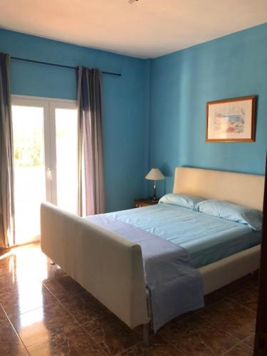 松塞拉德马里纳Chalet Son Serra的一间拥有蓝色墙壁的卧室和一张位于客房内的床