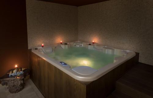 马罗尼亚King Maron Wellness Beach Hotel的浴室配有带蜡烛的浴缸。