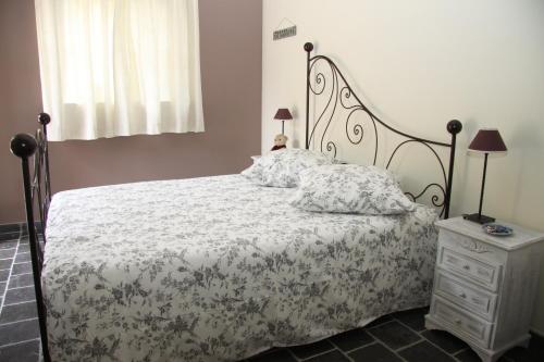 圣费利西安巴士底德芳塔伊民宿的一间卧室配有一张床和一个带床罩的梳妆台