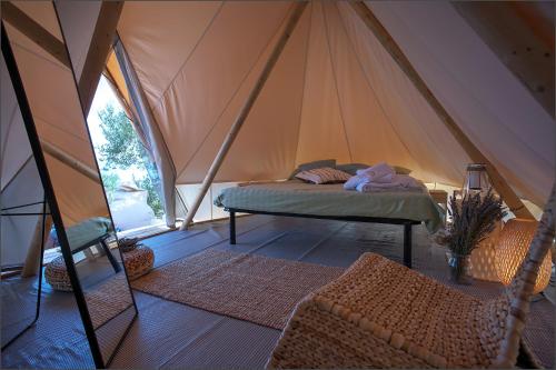 PristanišćeGlamping resort Fešta Kornati的帐篷内一间卧室,配有一张床