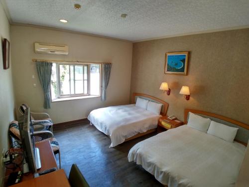 Liugui芳晨温泉渡假村 的酒店客房设有两张床和窗户。