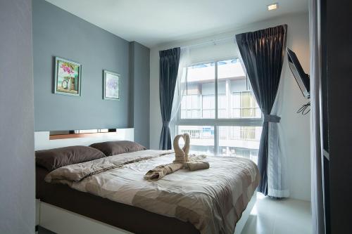 梅尔皮姆Grandblue Condo by malai的卧室里设有一张床,上面有一只动物