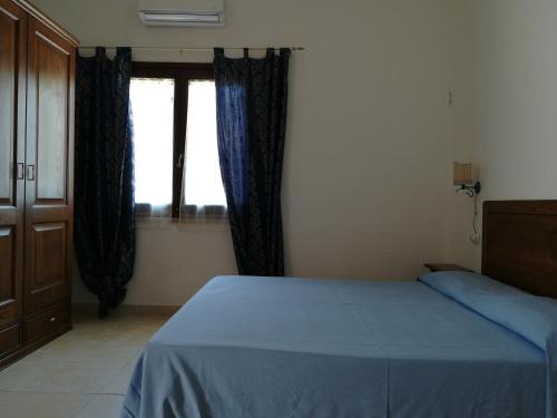 奥罗塞伊Agriturismo Sa Conca Ruia的一间卧室设有蓝色的床和窗户。
