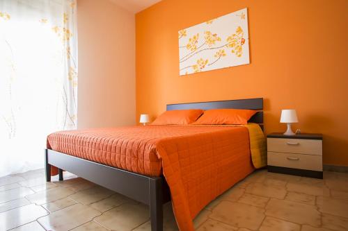 波托帕洛B&B Terra Nobile - Portopalo的一间卧室配有一张橙色墙壁的床