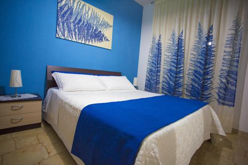 波托帕洛B&B Terra Nobile - Portopalo的蓝色的卧室,配有床和蓝色的墙壁