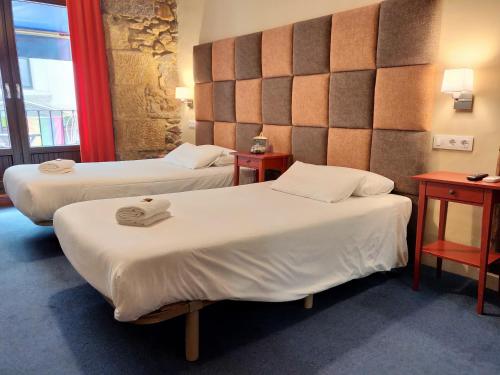 毕尔巴鄂伊图里娜奥斯塔图酒店的酒店客房,设有两张床和两张桌子