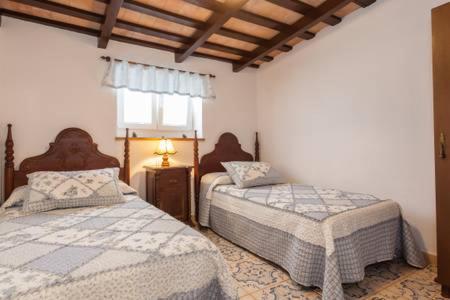 科尼尔-德拉弗龙特拉Casa rural-Granja (La casa de la abuela Juana)的一间卧室设有两张床和窗户。
