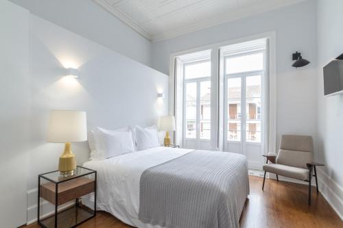 科英布拉AQ 188 Guest House的白色卧室配有床和椅子