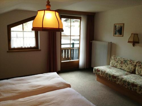 卡普伦Landhaus Griesser的一间卧室配有一张床、一张沙发和一个窗口