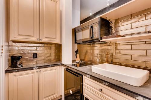 丹佛维多利亚时代假日旅馆的厨房配有水槽和台面