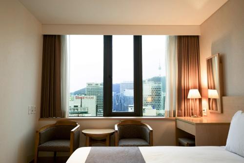 首尔首尔G地酒店的酒店客房设有一张床和一个大窗户