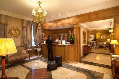 巴黎巴黎梅费尔酒店的站在酒店房间柜台上的人