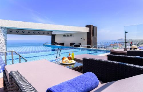 济州市济州格拉贝尔酒店的从房子的阳台上可欣赏到游泳池的景色