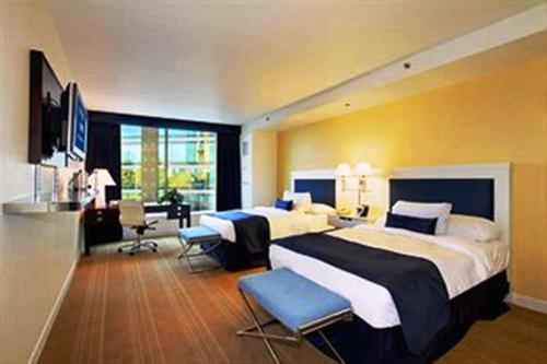 斯托克顿大学广场海滨酒店的大型酒店客房设有两张床和一张书桌