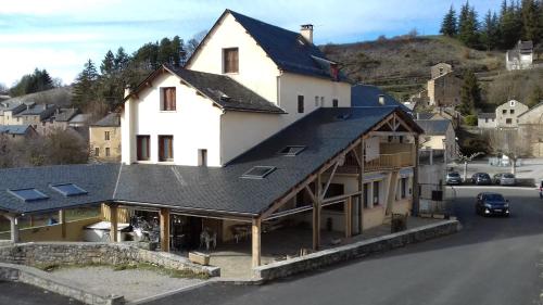 LanuéjolsHôtel Le Bel Air的屋顶上设有太阳能电池板的房子