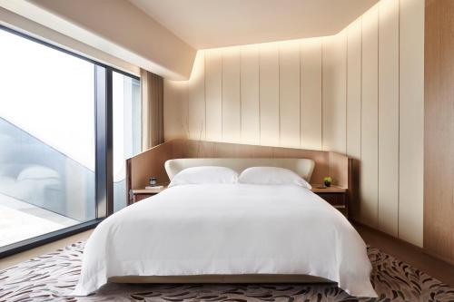 澳门新濠天地 -摩珀斯的卧室设有白色的床和大窗户