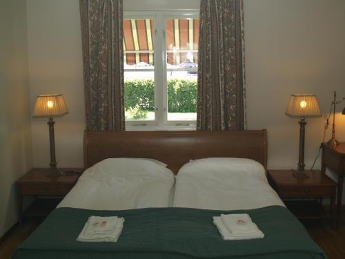 南雪平劳伦蒂酒店的一间卧室配有一张床,上面有两条毛巾