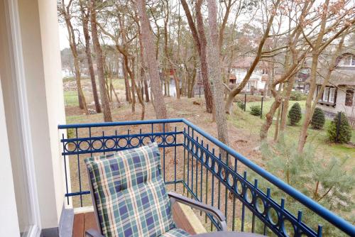巴贝Baabe Gruene Duene Fewo Sommerfris的阳台配有椅子,享有树林美景