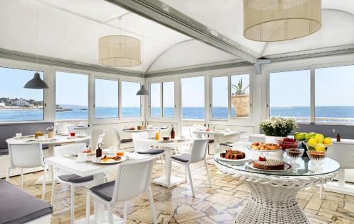 圣塔马利奈拉Villa delle Palme的一间设有白色桌椅的海洋餐厅