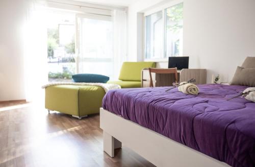 弗尔赫尼卡Nauportus的一间卧室配有一张紫色的床和一把椅子