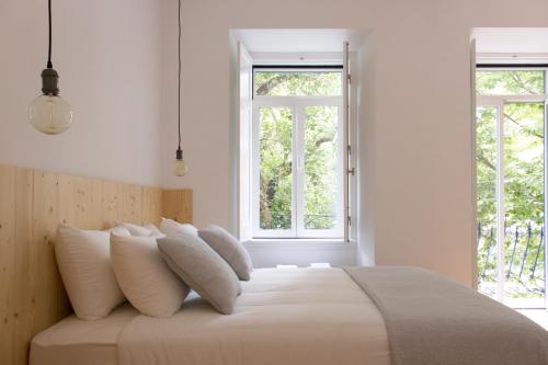 里斯本Destino Lisboa Apartments的白色卧室配有一张带白色枕头的大床