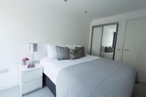 爱丁堡Gillespie House的白色卧室设有一张大床和镜子