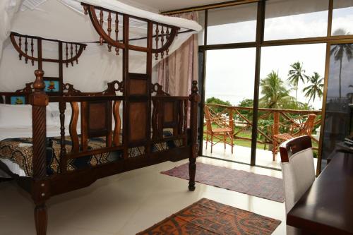 乌罗阿Coconut Tree Village Beach Resort的一间卧室设有一张床和一个阳台
