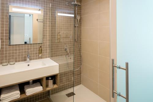 拉卡诺奥肯Hôtel Vitalparc的一间带水槽和淋浴的浴室