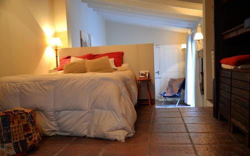 坦迪尔Loft Urbano的一间卧室配有一张带红色枕头的大床