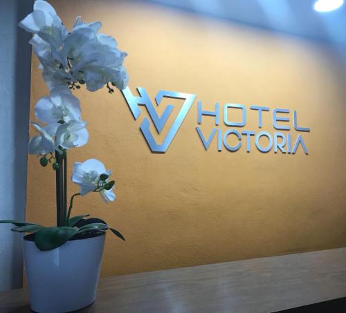 蒙特雷Hotel Victoria的在酒店标志前的白色花瓶