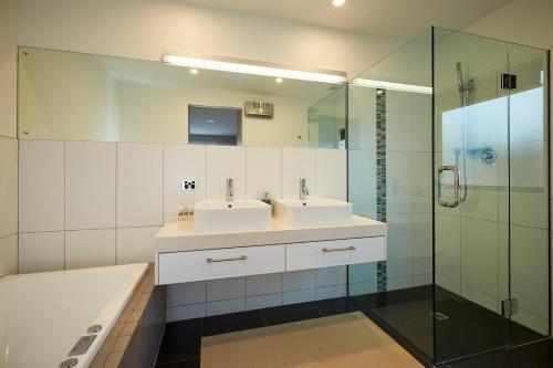 凯库拉The Fairways Luxury Accommodation Kaikoura的一间带两个盥洗盆和淋浴的浴室
