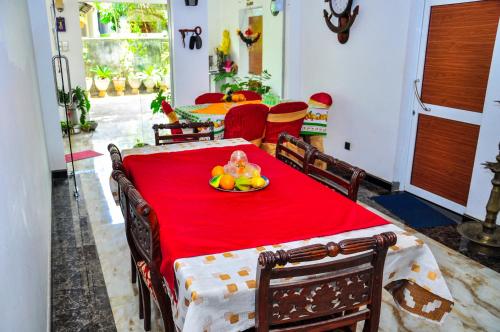 波隆纳鲁沃Rock Cascade tourist home的一张红色桌子,上面有一盘水果