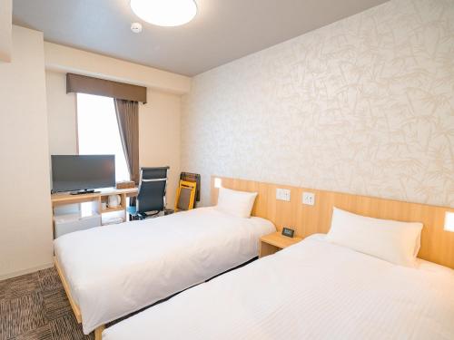 佐渡市佐渡旅程酒店的酒店客房配有两张床和一张书桌