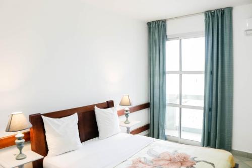 杜阿拉Tchero Appartement 1的一间卧室设有一张床和一个大窗户