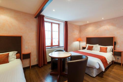 JougneLa Couronne的酒店客房设有两张床和一张桌子。