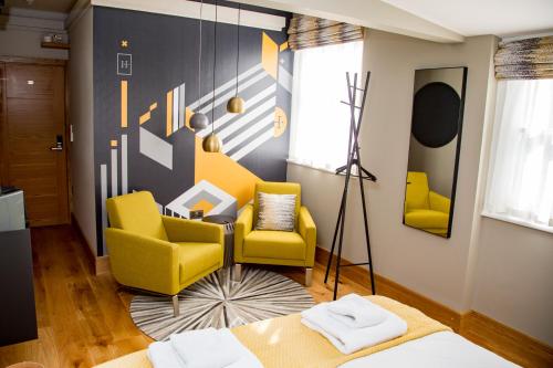 坎特伯雷The Hugo - Hotel Concept Canterbury的客厅配有黄色椅子和沙发