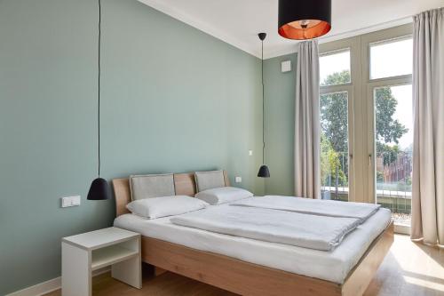 柏林Park Penthouses Insel Eiswerder的一间卧室设有一张大床和一个大窗户