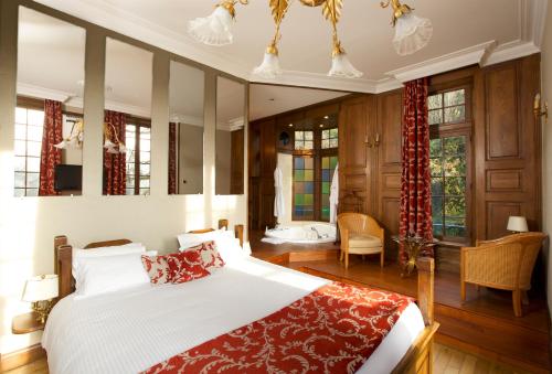 科内勒库奈尔磨坊酒店的一间卧室配有一张带红色毯子的大床
