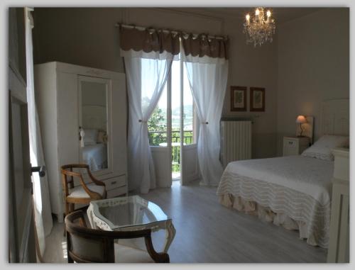 MelazzoCascina Luvot的卧室配有一张床和一张桌子及椅子