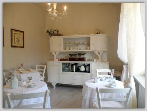 MelazzoCascina Luvot的一间设有两张桌子和白色橱柜的用餐室