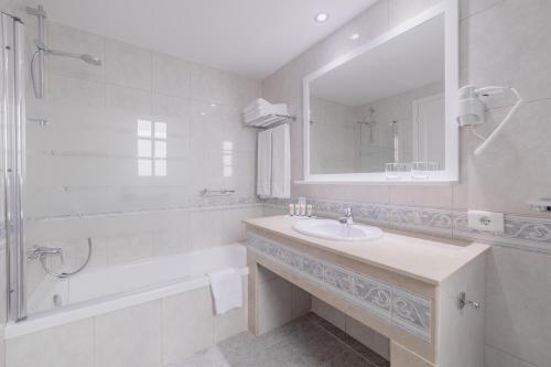 马斯帕洛马斯维斯塔塞里娜俱乐部酒店的一间带水槽、浴缸和镜子的浴室