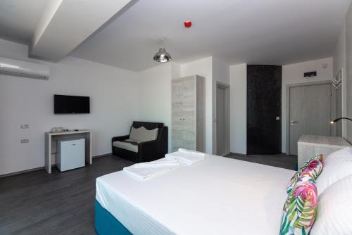 艾福雷诺德Hotel H pe plaja Belona的卧室配有白色的床和椅子