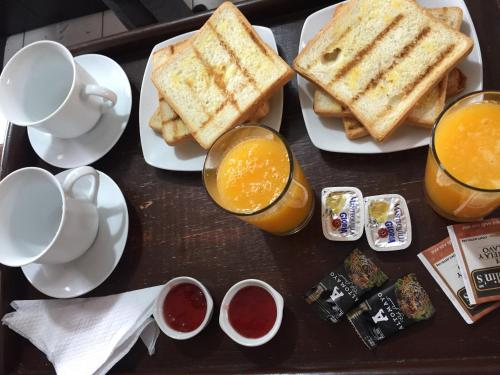 塔克纳Majestuoso Hospedaje的包括烤面包和橙汁的早餐托盘