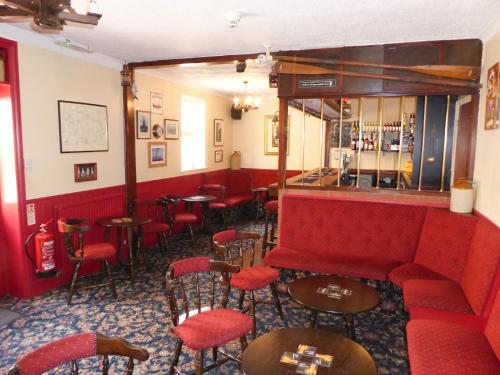 桑当德尼沃蒂酒店的一间酒吧,配有红色的沙发和桌椅