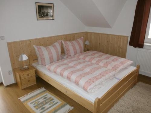 温佩尔克Apartman Hrabice的一间卧室配有带粉色和白色枕头的木床