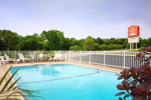 布兰森低语山汽车旅馆的一个带围栏、椅子和标志的游泳池
