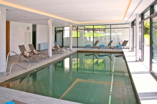 拉古多Hotel Flora的一座带椅子的建筑中的游泳池