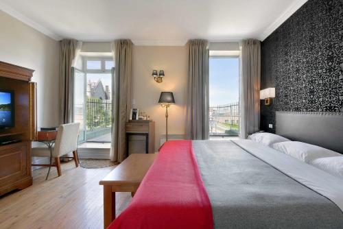 蒙特利尔波拿巴特酒店的一间卧室配有一张大床、一张书桌和窗户。