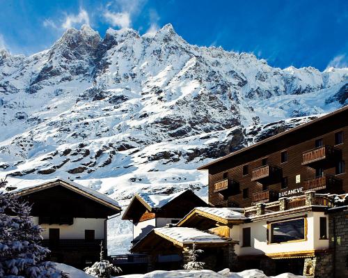 布勒伊-切尔维尼亚布卡奈维酒店的一座建筑物前的雪覆盖的山